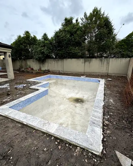 Bundall: fresh coping and waterline tiles over the existing pebblecrete